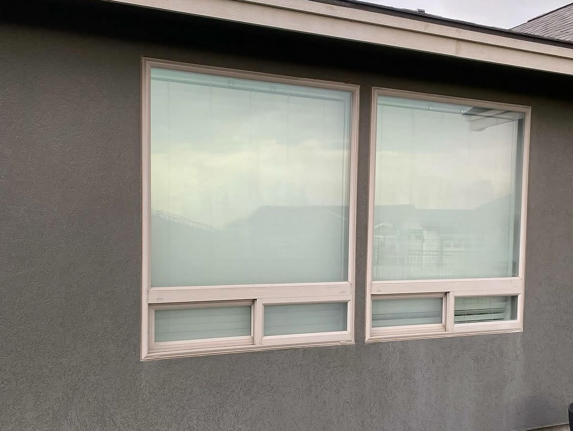 Two large windows on a Richland home before and after hard water spot removal (before)